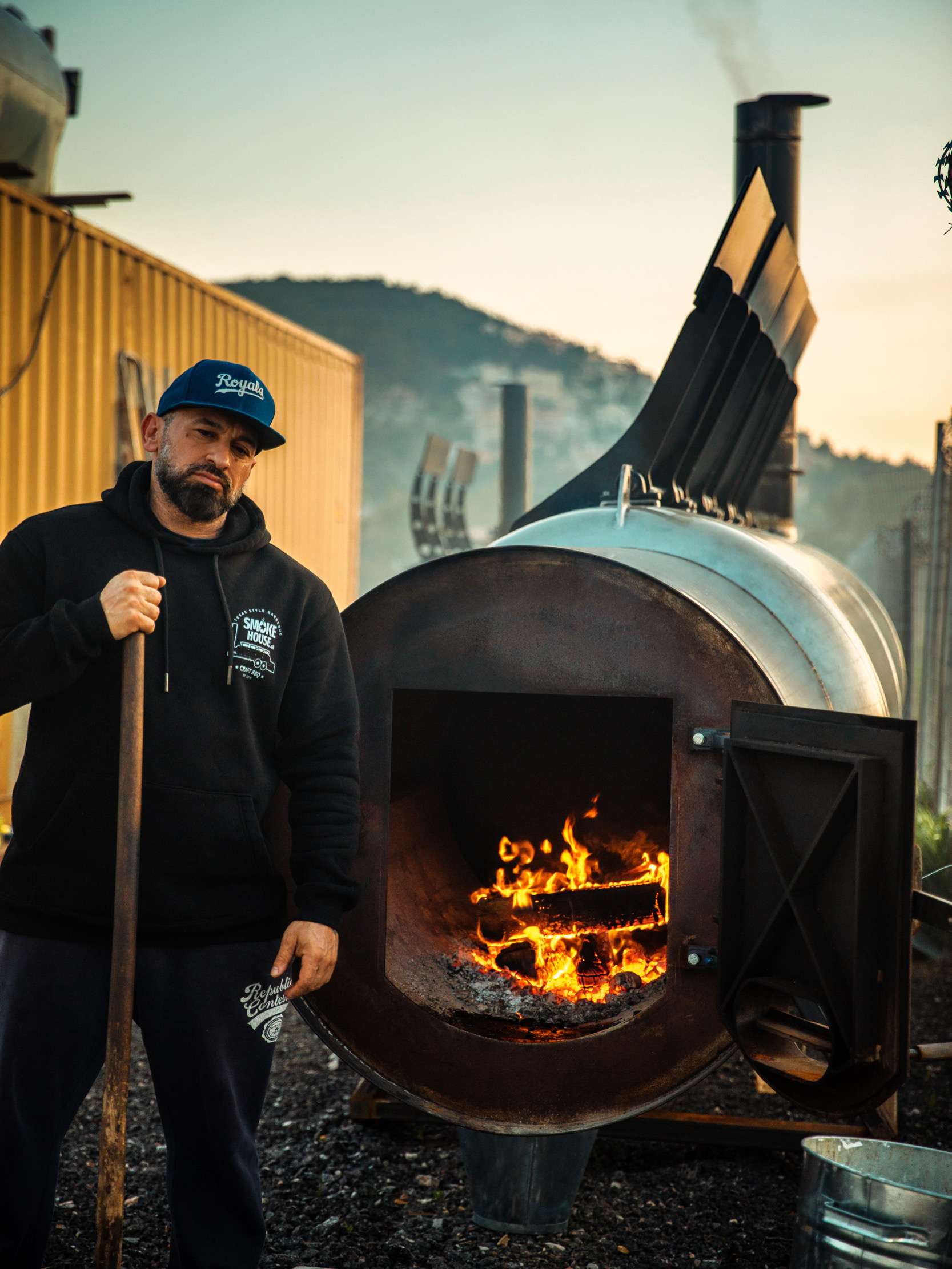 Ο Τάκης δίπλα στον αναμμένο offset smoker του Smoke House Greece.