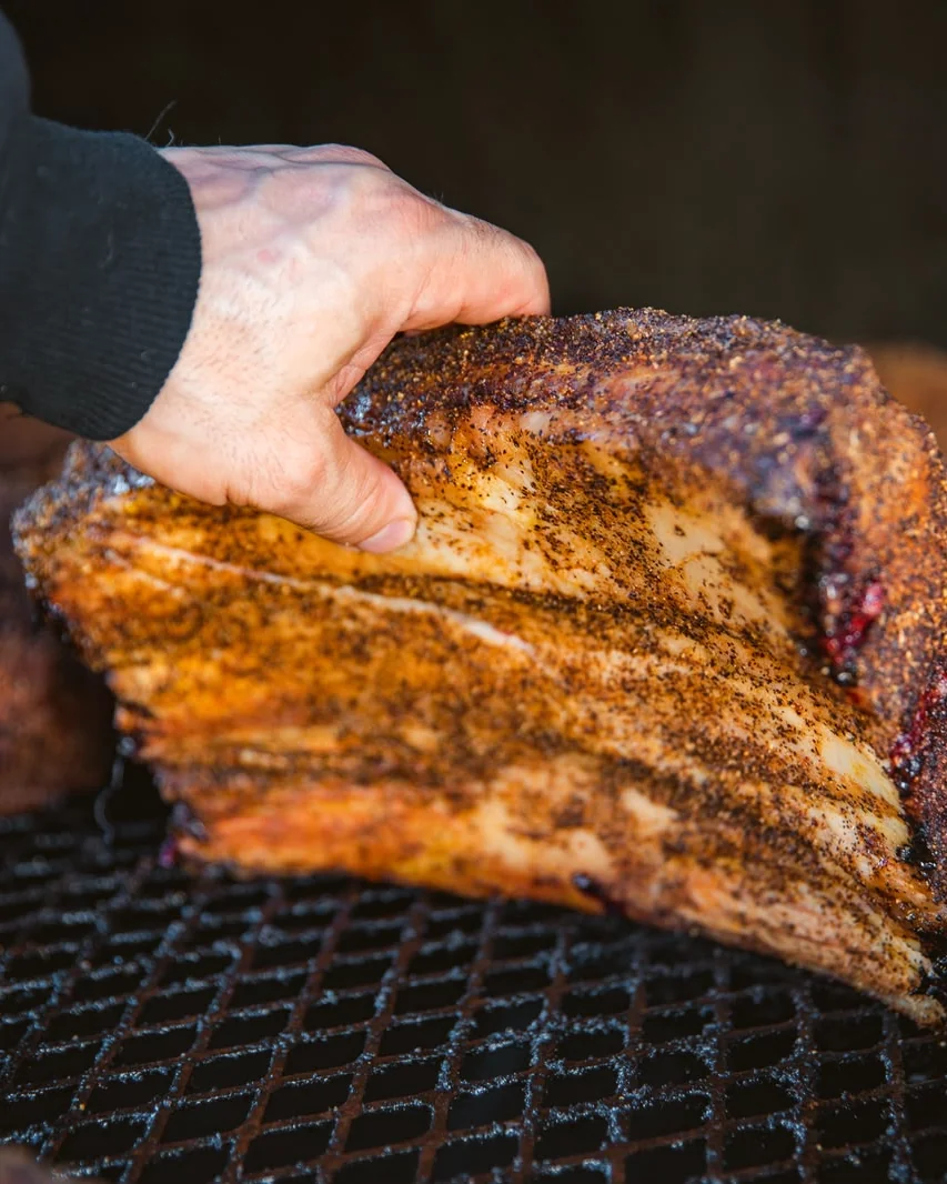 Καπνιστό pork belly με rub, καθώς σηκώνεται από τη σχάρα του smoker